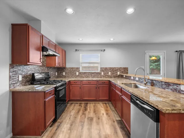 a kitchen with a sink stove top oven and cabinets