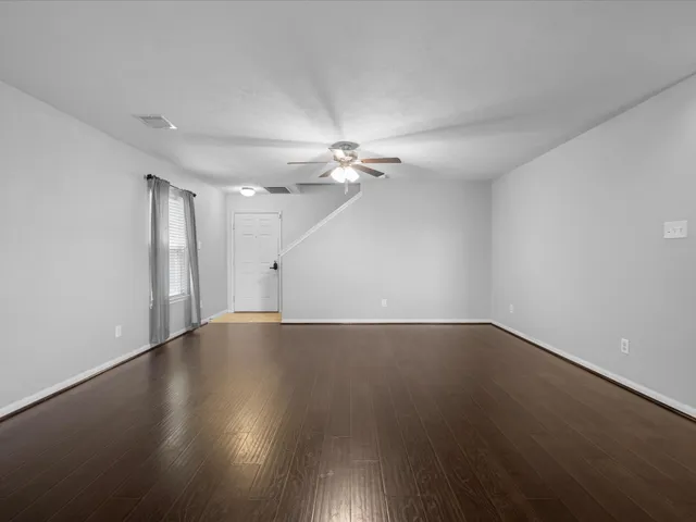 a view of an empty room with wooden floor