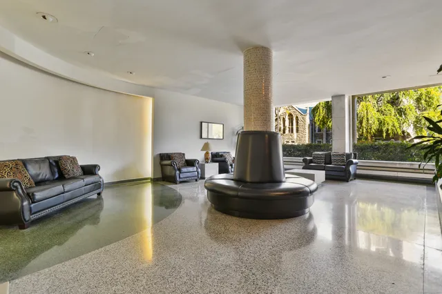 a living room with fireplace furniture and a large window