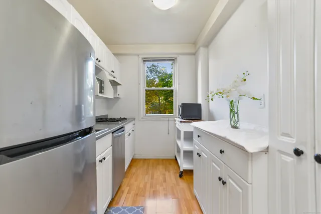 a kitchen with a sink appliances cabinets and a window