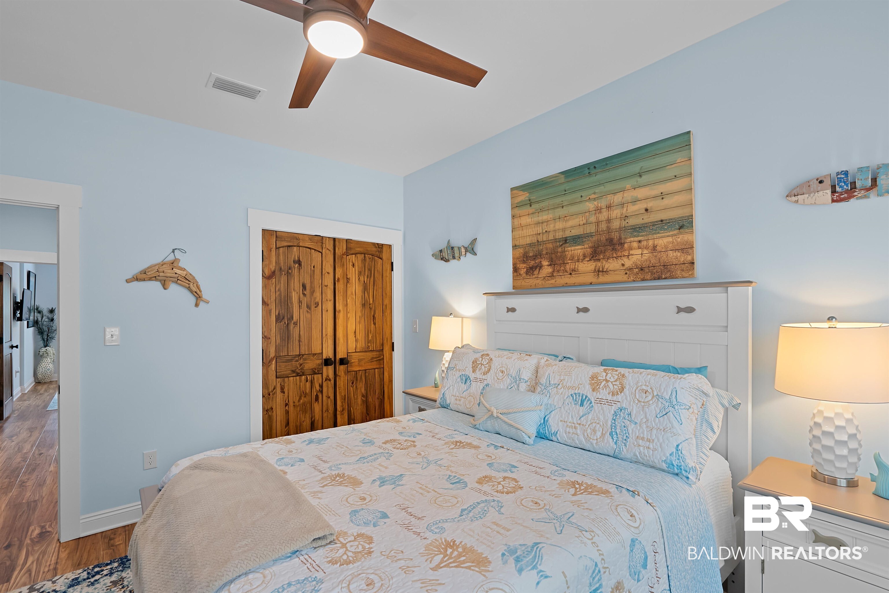 7266 Franklin Road Foley, AL 36535 - Photo 31 of 64 Bedroom with a wooden ceiling fan, light blue walls, and a pair of natural wood barn-style doors