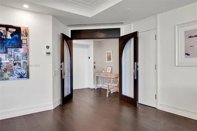 a view of a hallway with bathroom and wooden floor