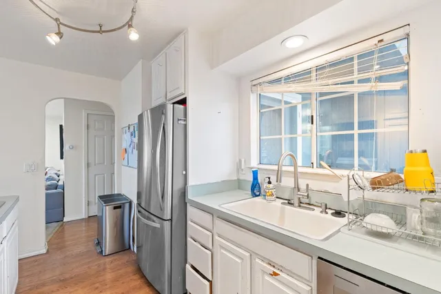 a kitchen with stainless steel appliances granite countertop a refrigerator and a sink