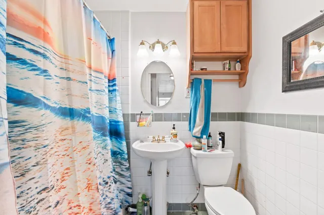 a bathroom with a sink and mirror with toilet