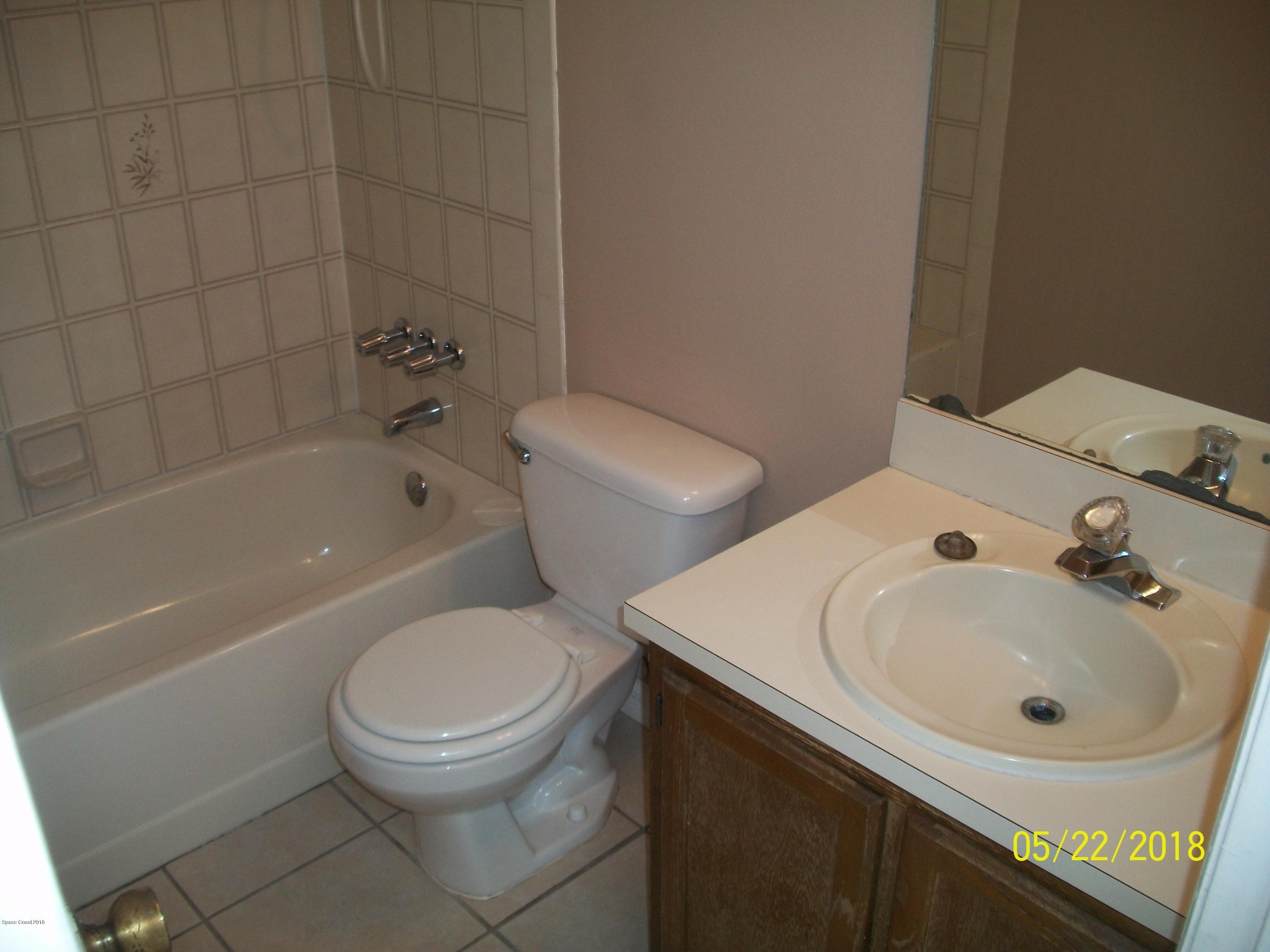 4910 Greenhill Street Cocoa, FL 32927 - Photo 8 of 11 a white toilet sitting next to a bathroom sink