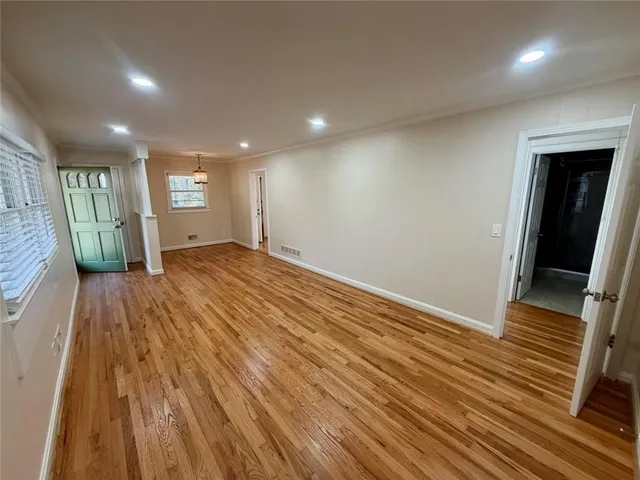 an empty room with wooden floor and entrance