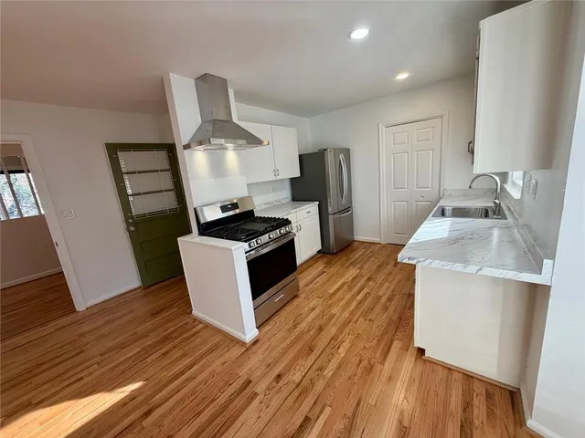 a kitchen with sink a refrigerator and wooden floor