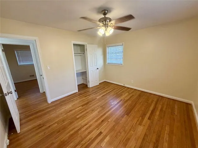 a view of empty room with wooden floor