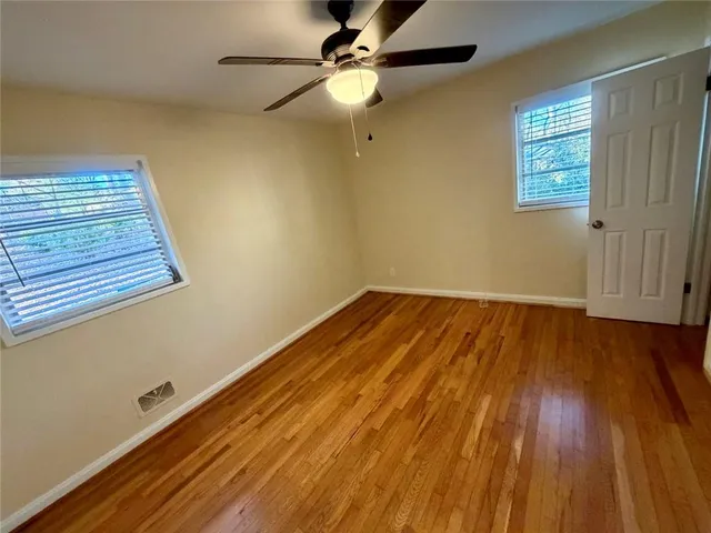 a view of room with wooden floor and fan