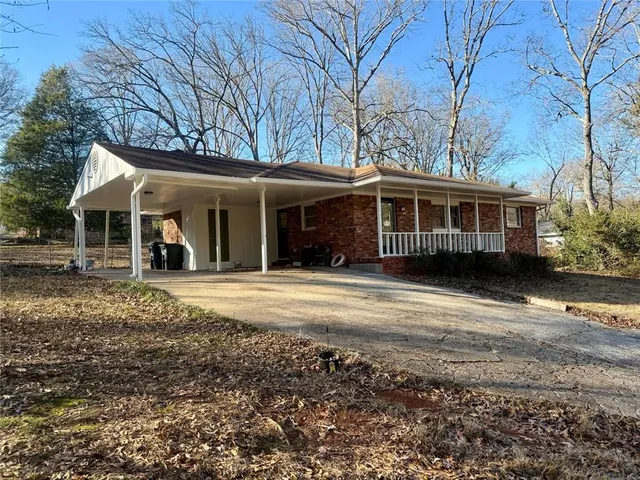 a view of a house with a yard and large trees