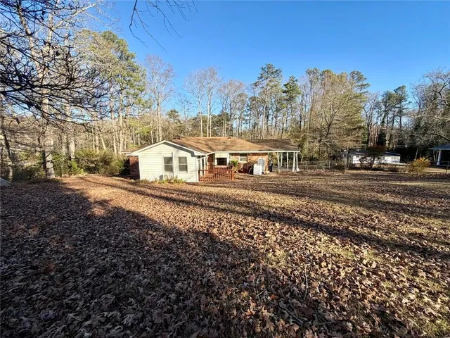 a view of a large white house with a yard covered with snow in the background