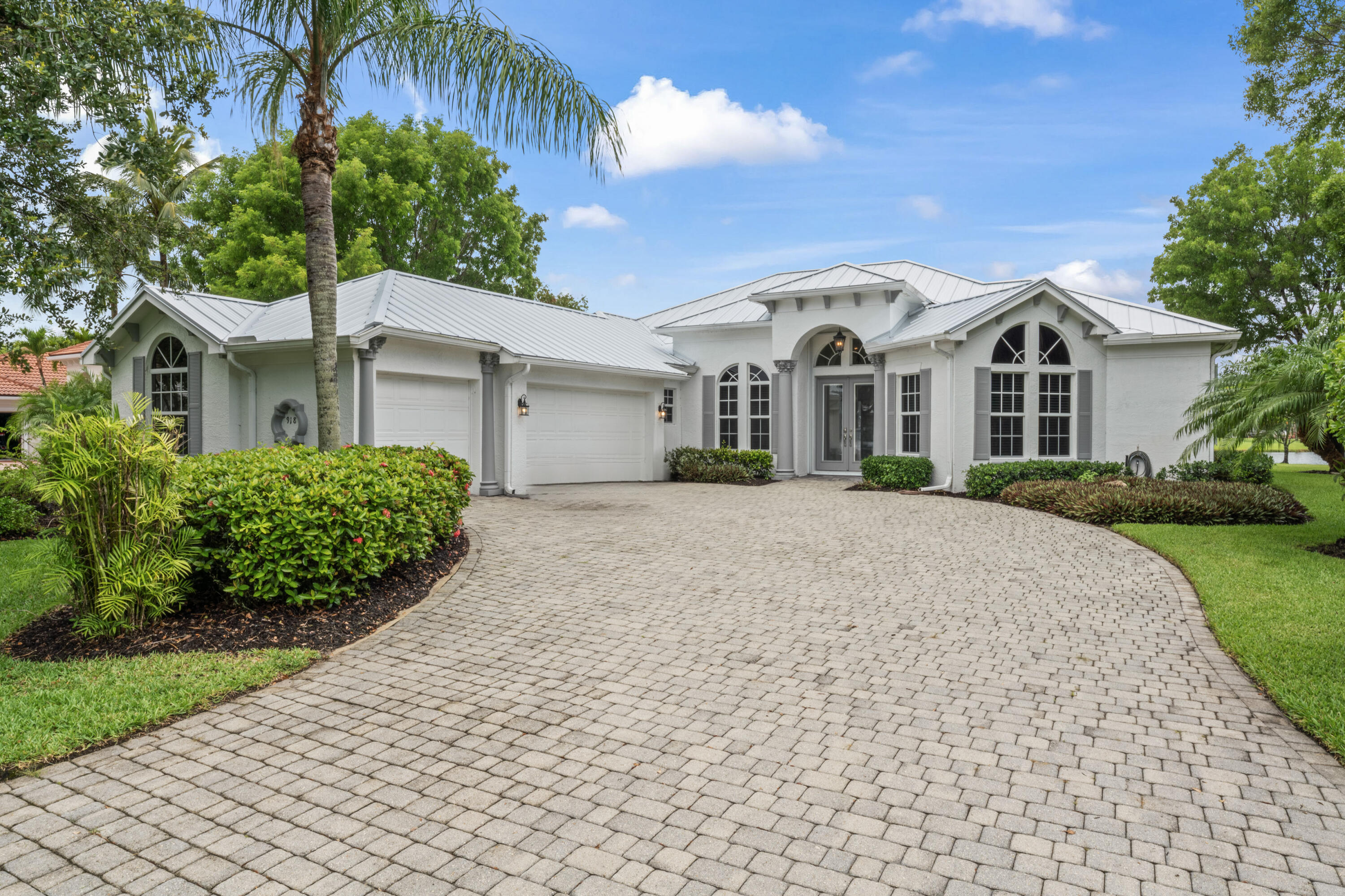 918 Southwest Blue Stem Way Stuart, FL 34997 - Photo 1 of 48 a front view of a house with a garden and plants