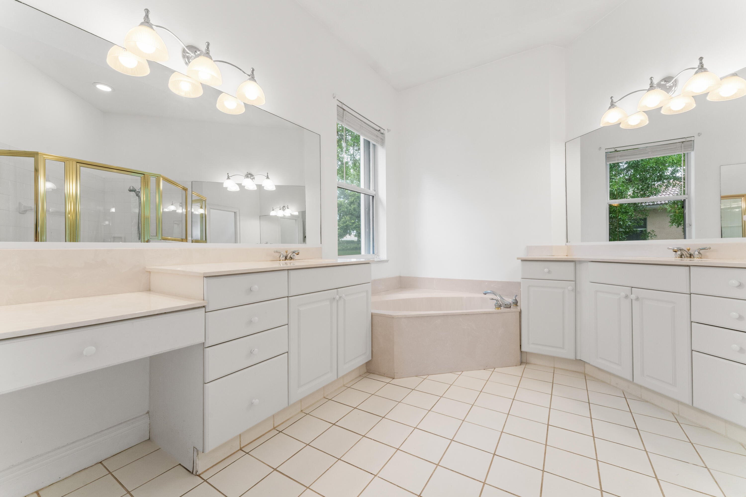 918 Southwest Blue Stem Way Stuart, FL 34997 - Photo 23 of 48 a large white bathroom with a large tub sink vanity and granite