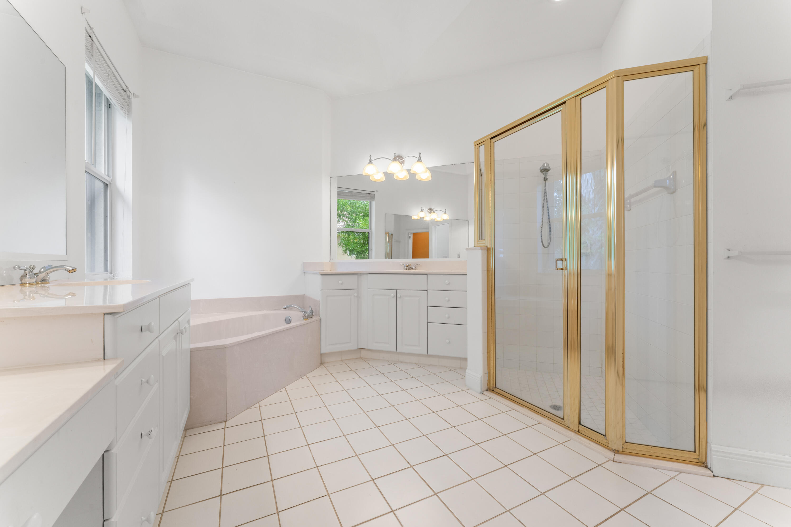 918 Southwest Blue Stem Way Stuart, FL 34997 - Photo 24 of 48 a spacious bathroom with a mirror a sink and a bathtub