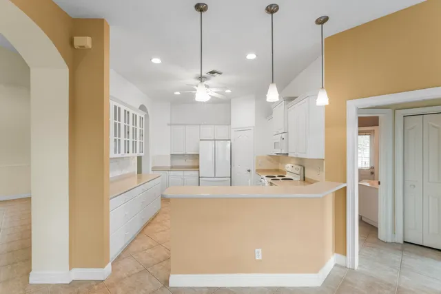 a view of a kitchen with kitchen island a sink stainless steel appliances and cabinets
