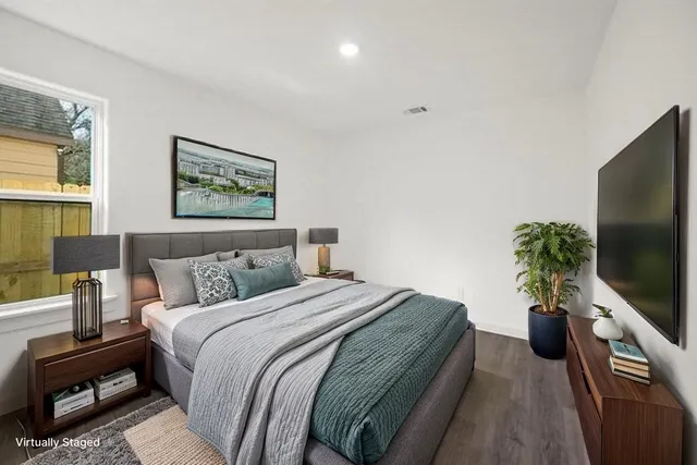 a bedroom with a bed and a flat screen tv