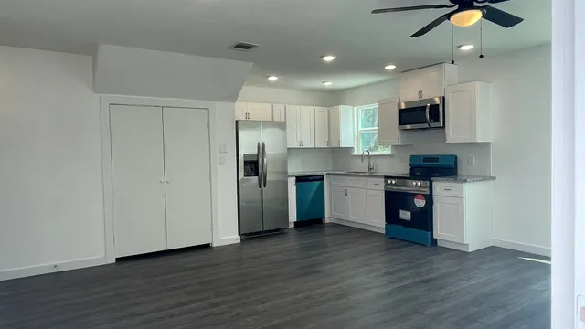 a kitchen with stainless steel appliances granite countertop a refrigerator and a stove top oven