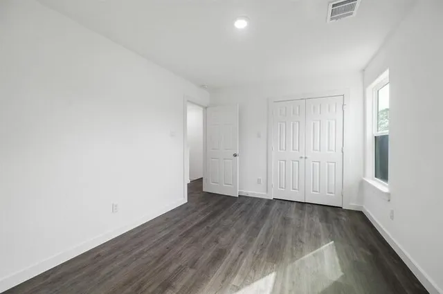a view of a room with wooden floor and white walls