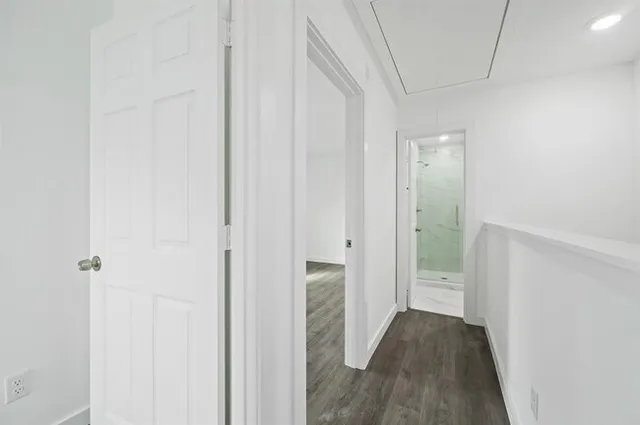 a view of a hallway with wooden floor and staircase