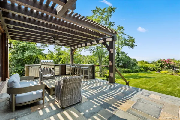 a view of a patio with couches chairs and wooden floor