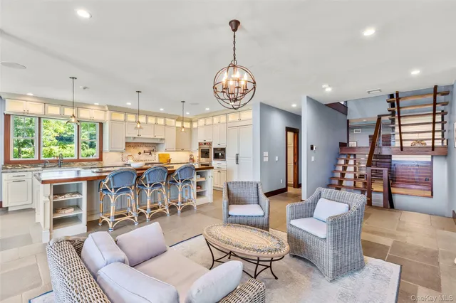 a living room with furniture kitchen view and a large window