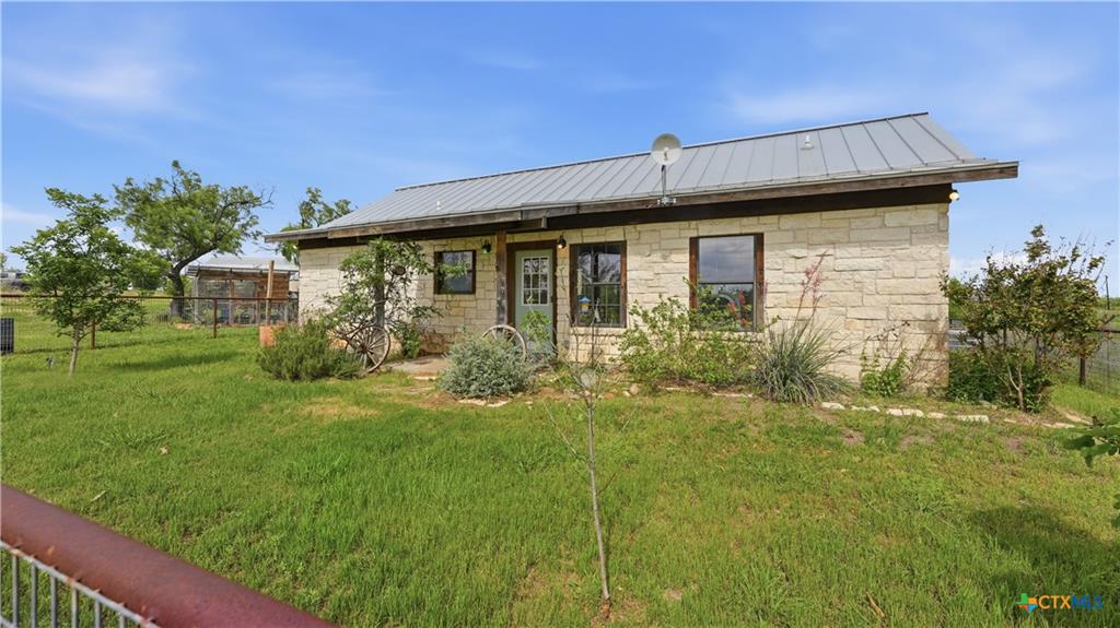 127 Offer Llano, TX 78643 - Photo 1 of 40 Stone exterior with a metal roof and exposed wood fascia