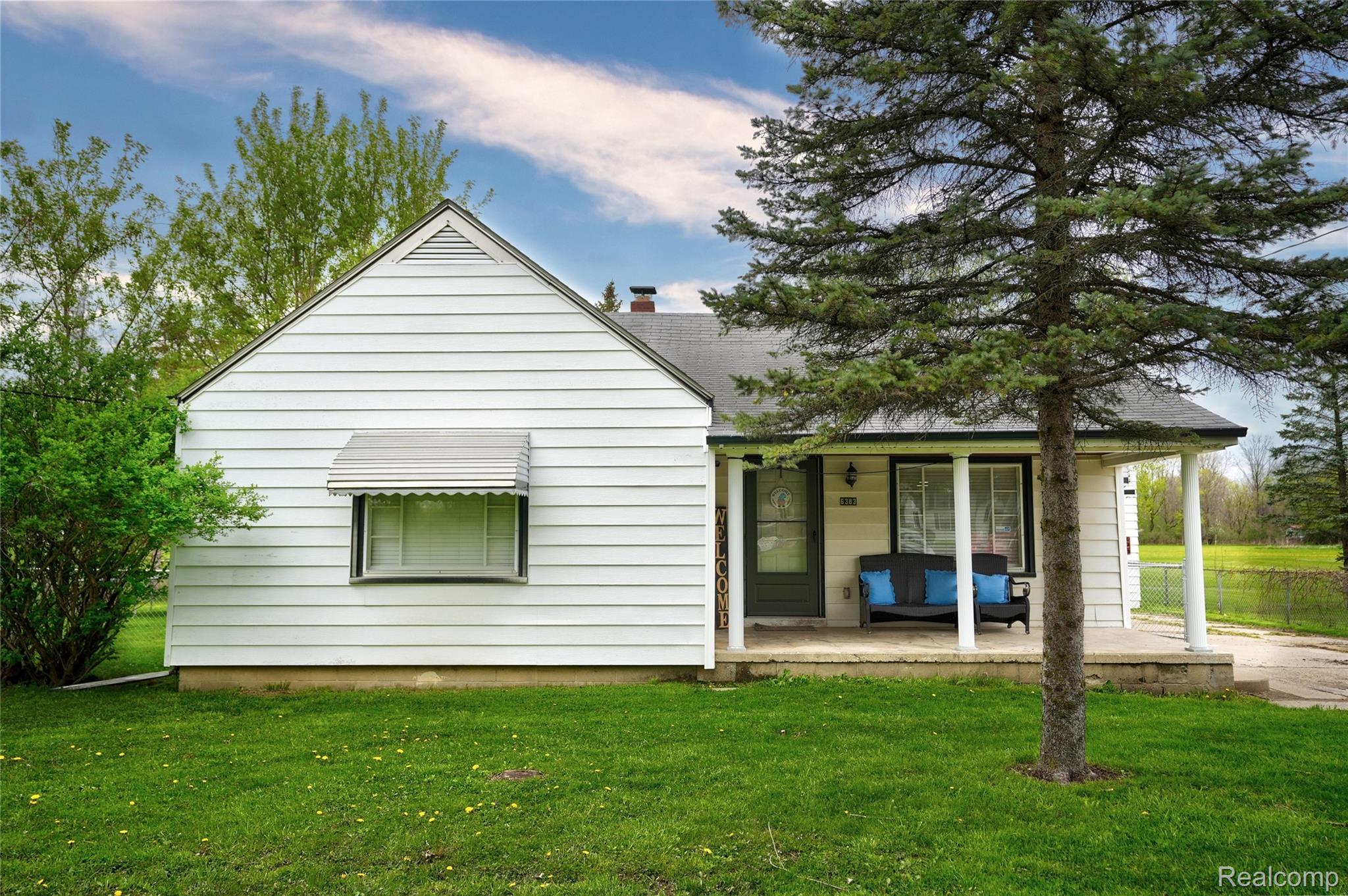 6383 Lapeer Road Burton, MI 48509 - Photo 39 of 44 Back of house with a yard, a porch, and a chimney