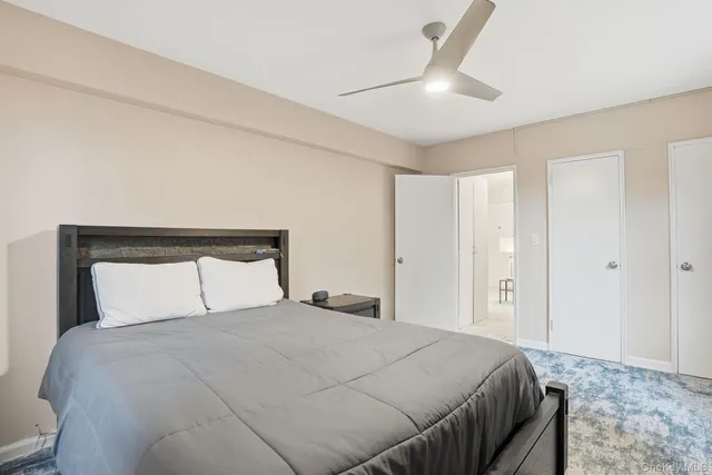a bedroom with a large bed and a ceiling fan