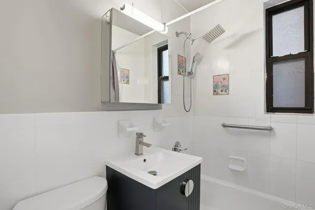 a bathroom with a sink mirror vanity and toilet