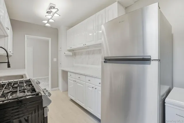a kitchen with white cabinets and white appliances