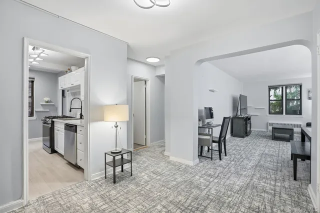 a living room with furniture a dining table and chairs next to a window