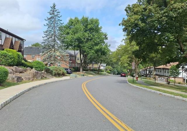 a view of street with houses and trees in the background