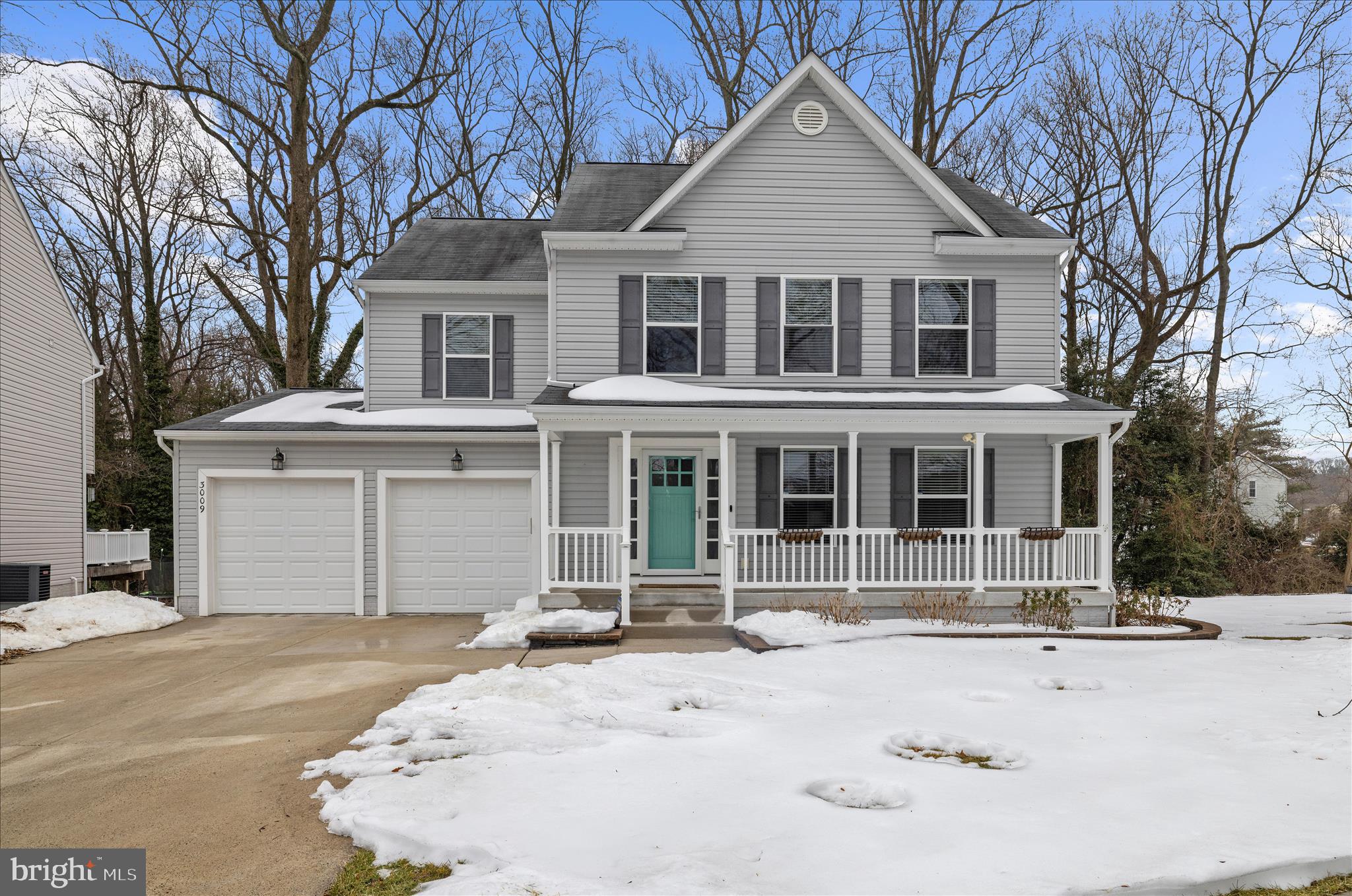 a front view of a house with a yard covered in snow