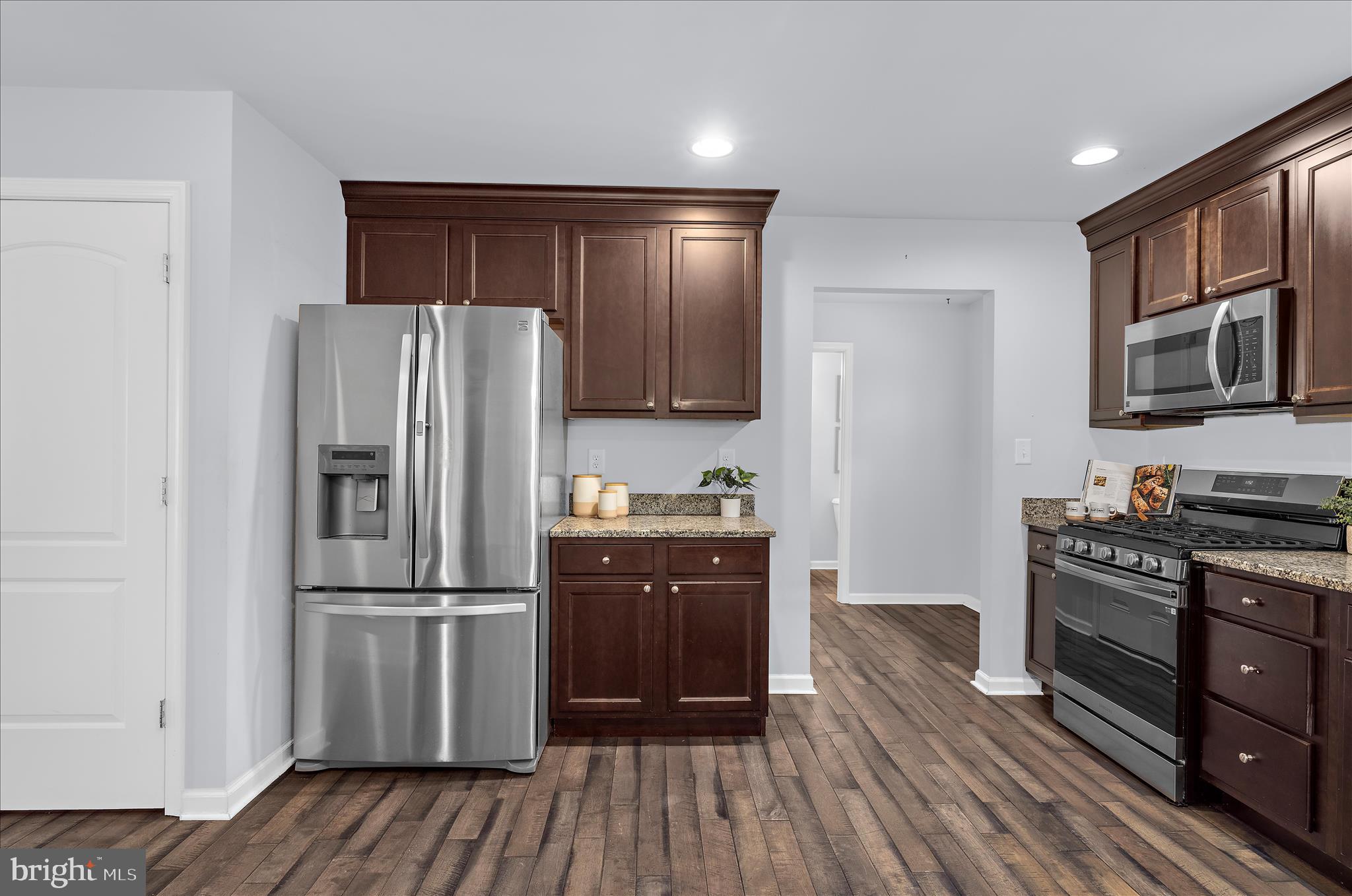 3009 Noahs Way Pasadena, MD 21122 - Photo 13 of 44 a kitchen with wooden floors stainless steel appliances and cabinets