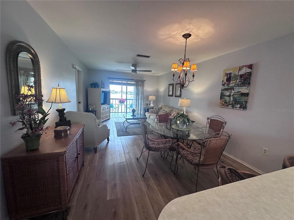 25225 Rampart Boulevard, Unit 105 Punta Gorda, FL 33983 - Photo 11 of 40 a view of a dining room and livingroom with furniture wooden floor a chandelier