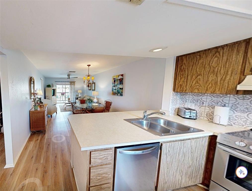 25225 Rampart Boulevard, Unit 105 Punta Gorda, FL 33983 - Photo 13 of 40 a kitchen that has a sink and a stove with wooden floor