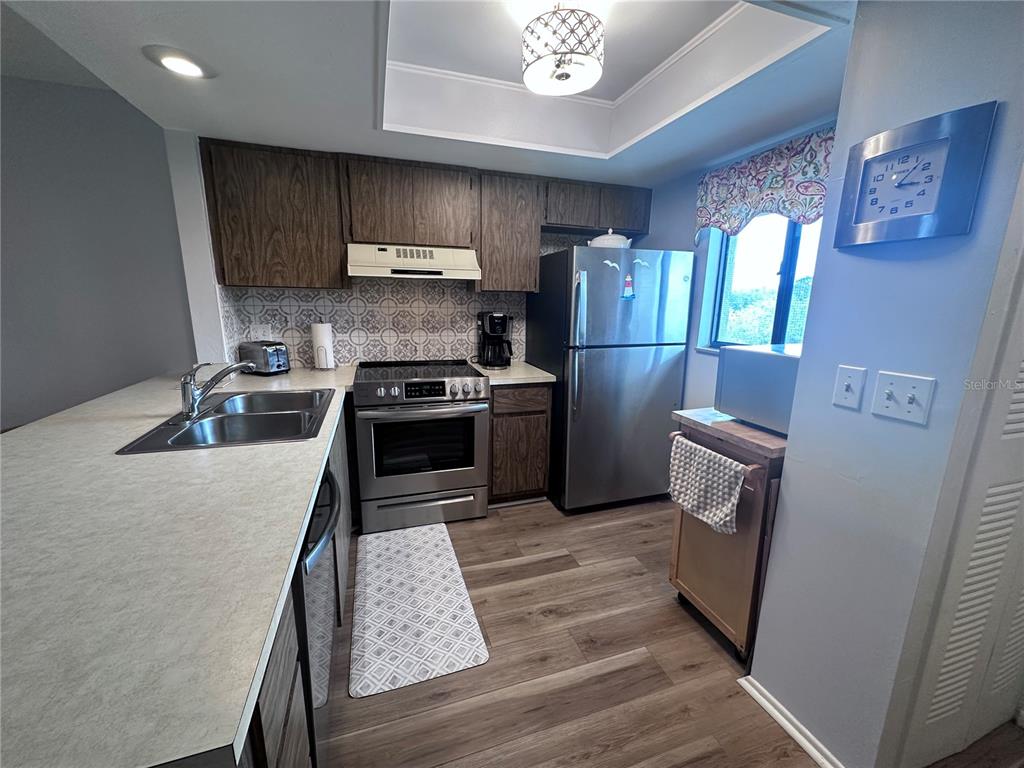 25225 Rampart Boulevard, Unit 105 Punta Gorda, FL 33983 - Photo 15 of 40 a kitchen with stainless steel appliances granite countertop a stove a sink dishwasher and a refrigerator