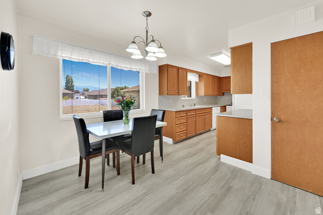 2467 South 2000 West Syracuse, UT 84075 - Photo 16 of 28 Open-concept dining area with large windows, wood-finish flooring, and a chandelier