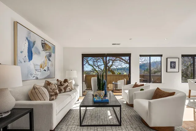 a living room with furniture a large window and a flat screen tv
