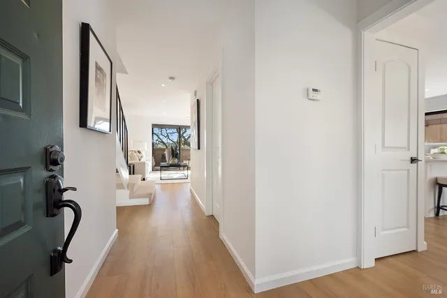 a view of a hallway with wooden floor and windows