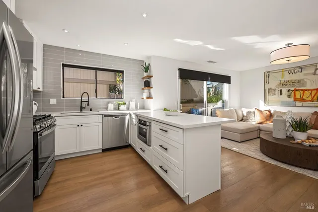 a view of kitchen with stainless steel appliances sink stove and refrigerator