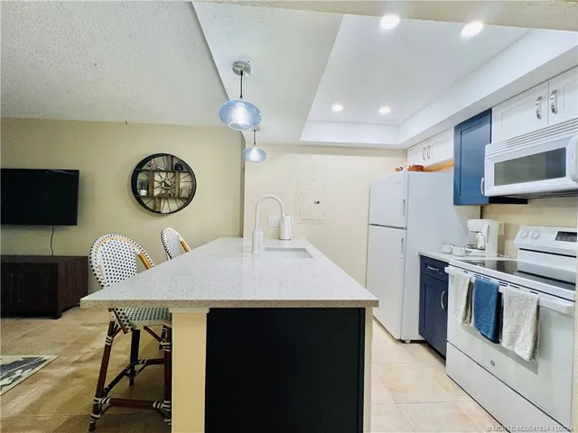 a kitchen with stainless steel appliances granite countertop a stove a refrigerator a oven a sink with a dining table and chairs