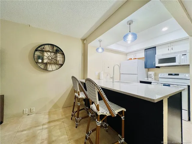 a kitchen with a table chairs a sink dishwasher and cabinets