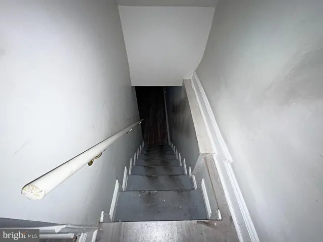 a view of empty room with wooden floor and stairs
