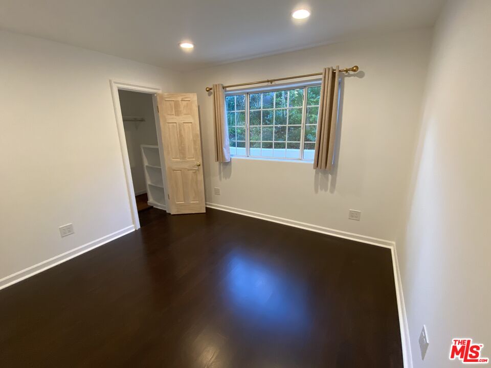 3900 Castlerock Road Malibu, CA 90265 - Photo 11 of 52 an empty room with wooden floor and windows