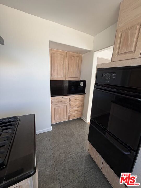 3900 Castlerock Road Malibu, CA 90265 - Photo 37 of 52 a kitchen with a stove and white cabinets