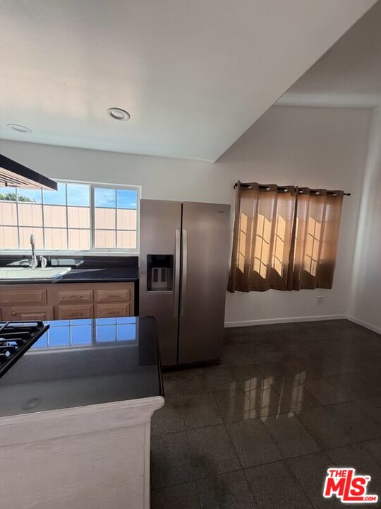 3900 Castlerock Road Malibu, CA 90265 - Photo 45 of 52 a kitchen with stainless steel appliances kitchen island granite countertop a refrigerator and a stove top oven