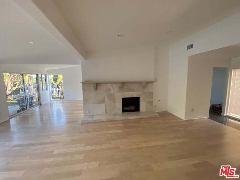 3900 Castlerock Road Malibu, CA 90265 - Photo 7 of 52 a view of empty room with wooden floor and fireplace