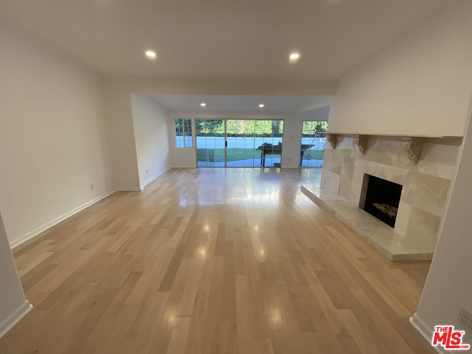 3900 Castlerock Road Malibu, CA 90265 - Photo 8 of 52 a view of empty room with wooden floor and fireplace