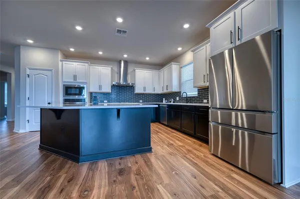 a kitchen with stainless steel appliances granite countertop a refrigerator a sink and a oven